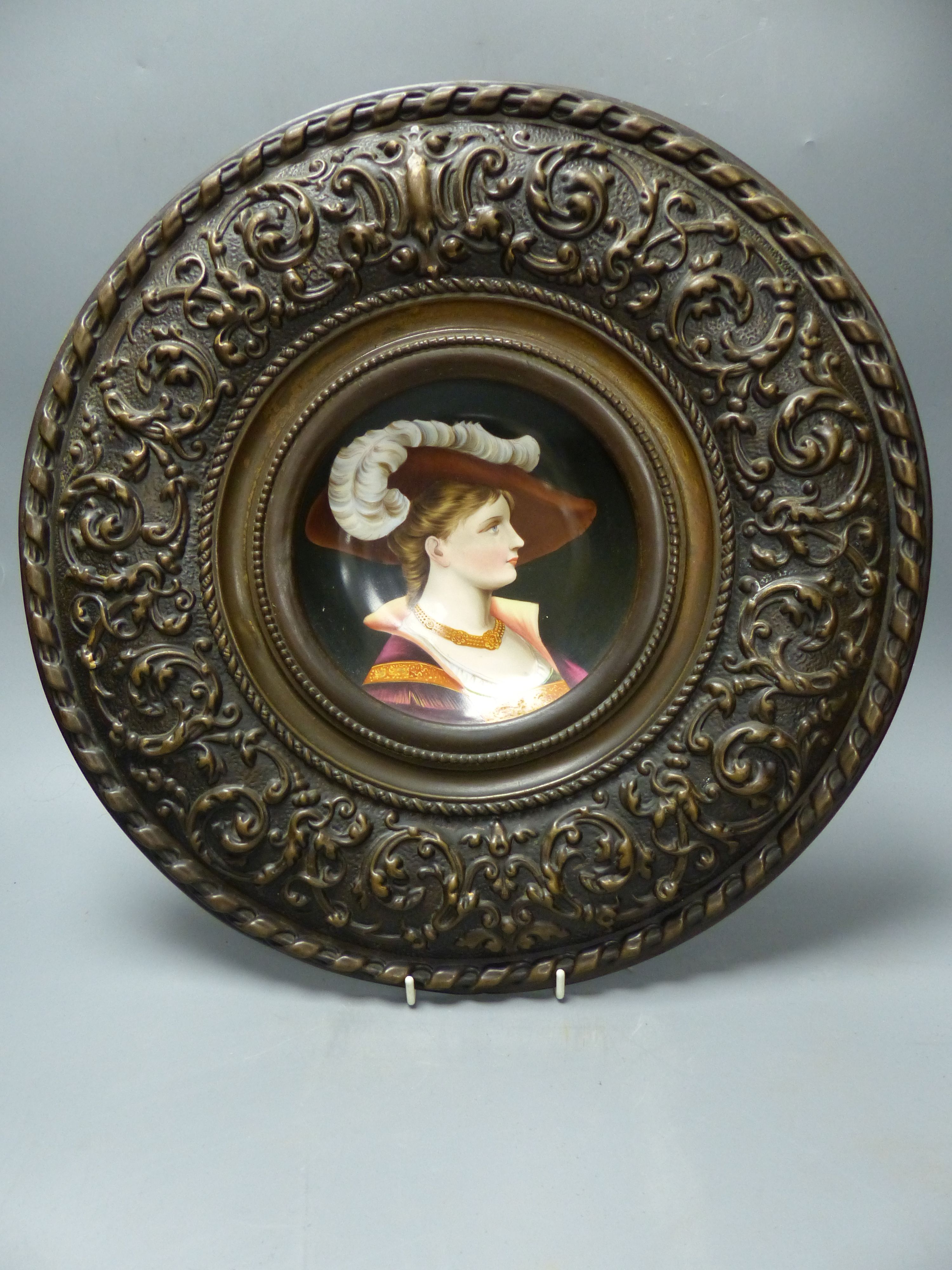 A French porcelain plaque in metal frame, overall diameter 40cm